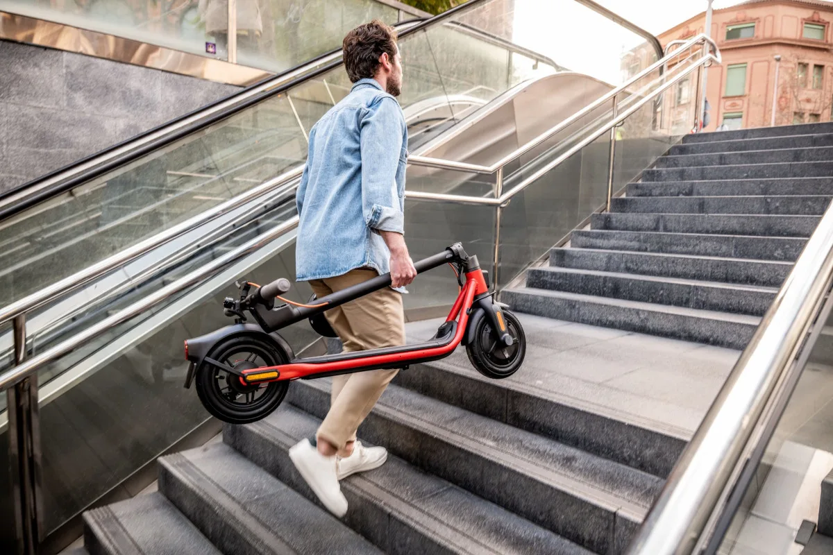 Ninebot KickScooter D18E, D28E und D38E einfach zusammenklappen und selbst Treppen hochtragen.