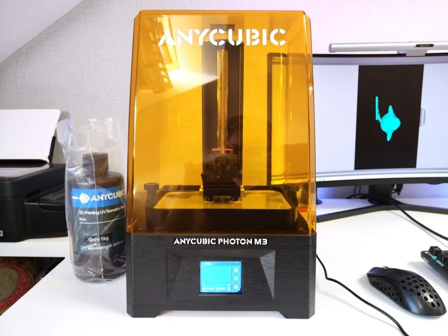 Anycubic Photon M3 ved siden af flaske med harpiks