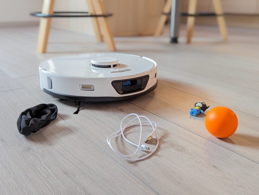 Divers objets sont devant le robot aspirateur