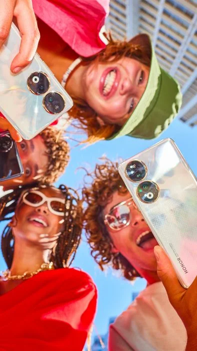 Fotografická skupina pro životní styl smartphonu HONOR 90 drží dva smartphony