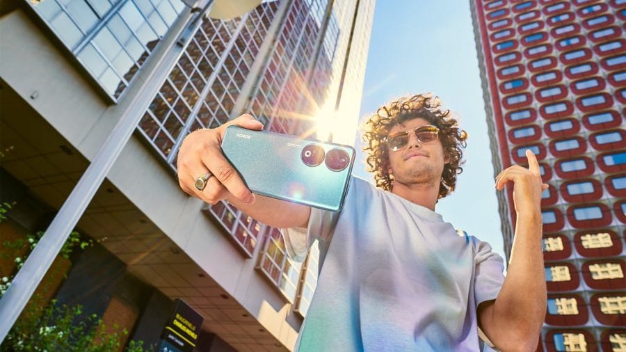 HOMEM com foto de estilo de vida do smartphone HONOR 90 segurando o smartphone na mão