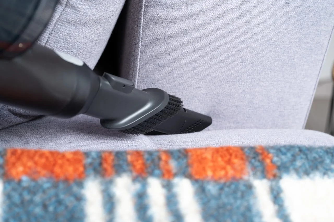 Tryska Roborock H60 Hub Ultra v spárě pohovky