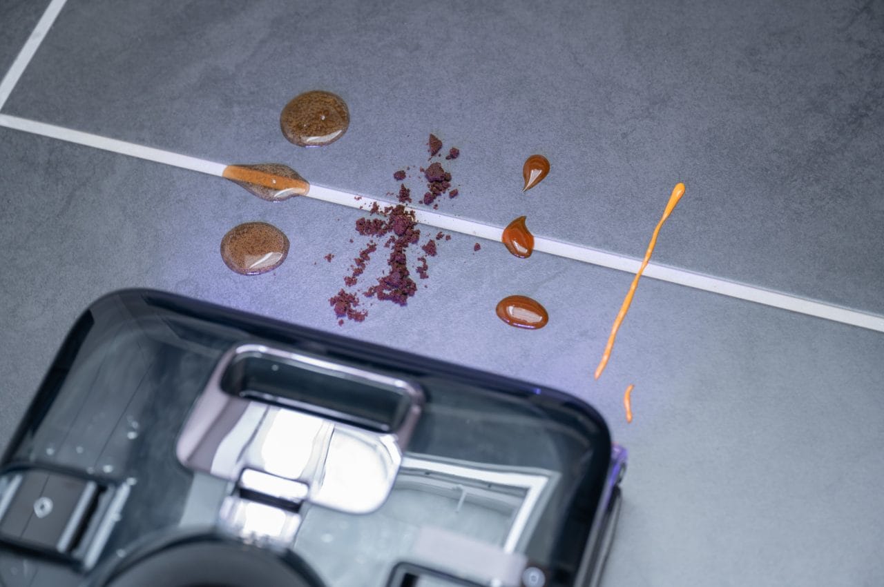 Roborock F25 Ultra vor Testfläche mit Cola, Kaffeesatz, Ketchup und Mayo